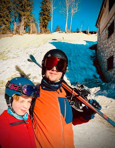 Un adulte et un enfant en tenue de ski, souriants